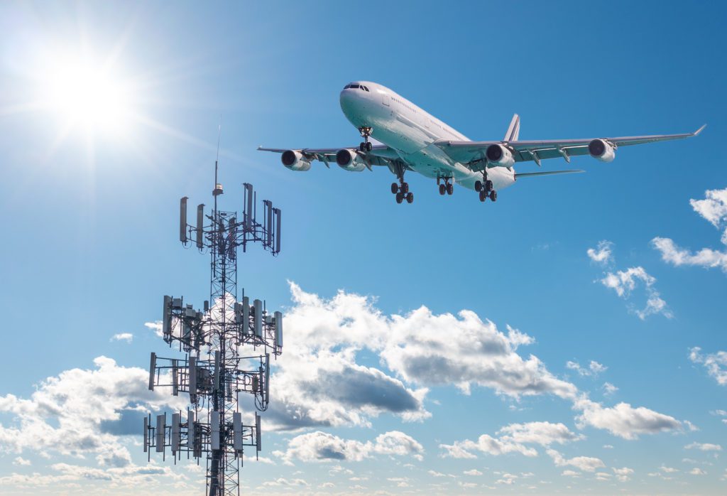 5G Cell phone or mobile service tower with aircraft approaching to land